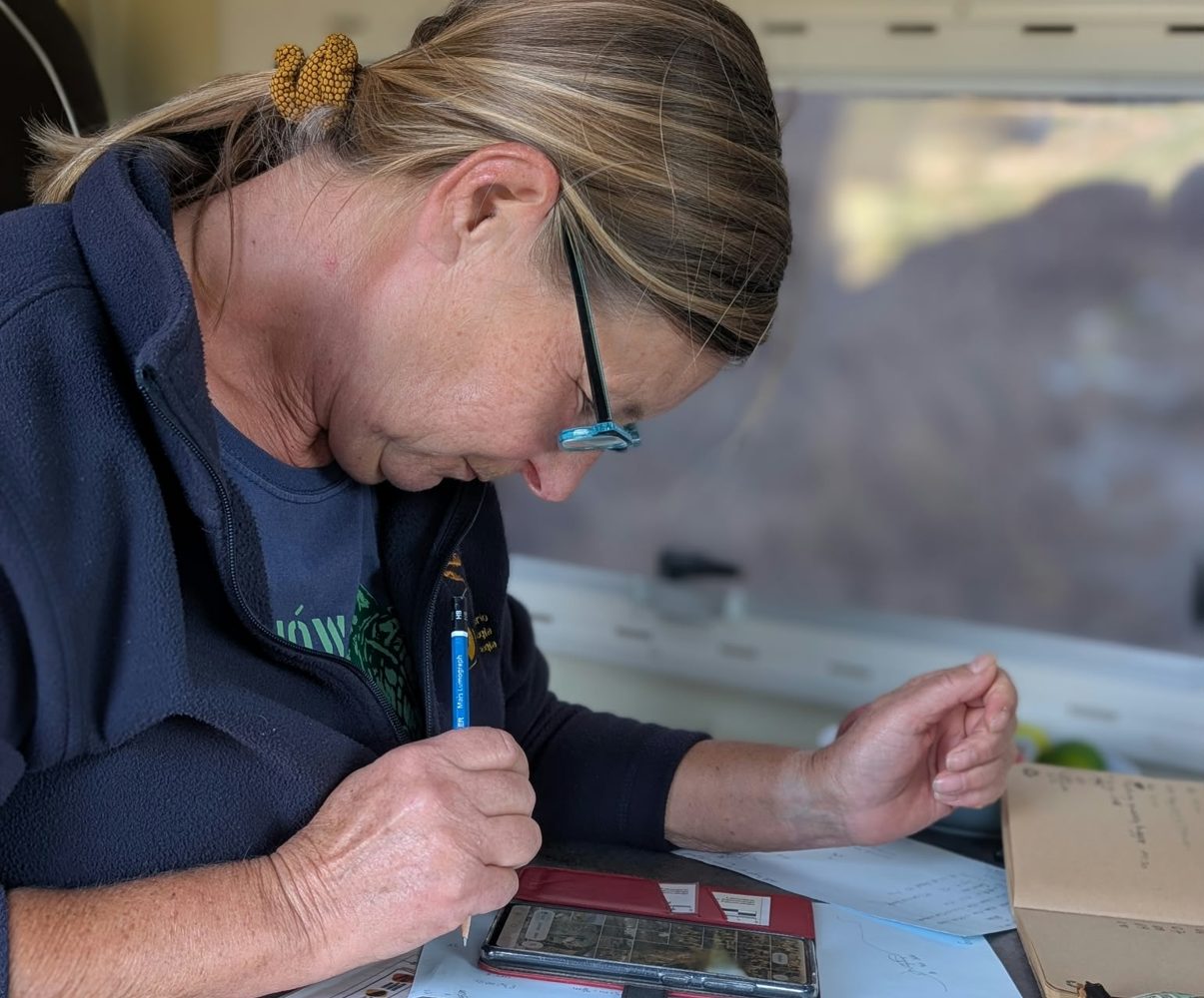A team member drawing a block map on paper with a pencil, a phone beside her