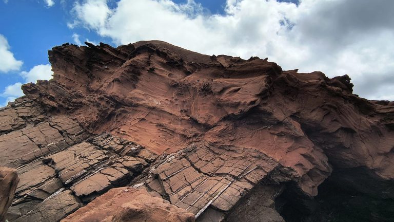 Weathered red sandstone outcrop under a blue sky