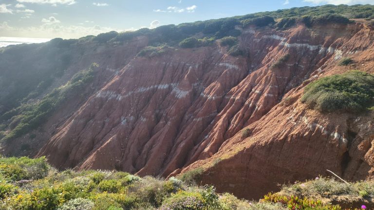 Eroded red hillside with pale bands of Triassic rock