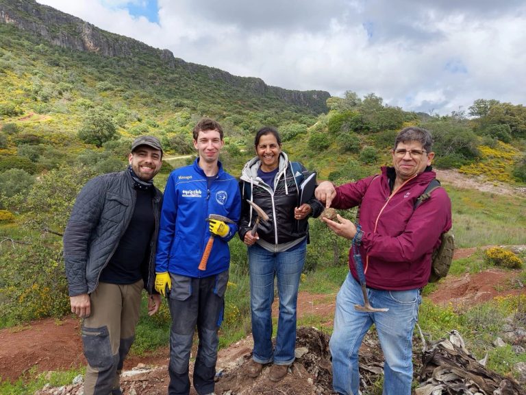 4 team members smiling in the hills during fieldwork