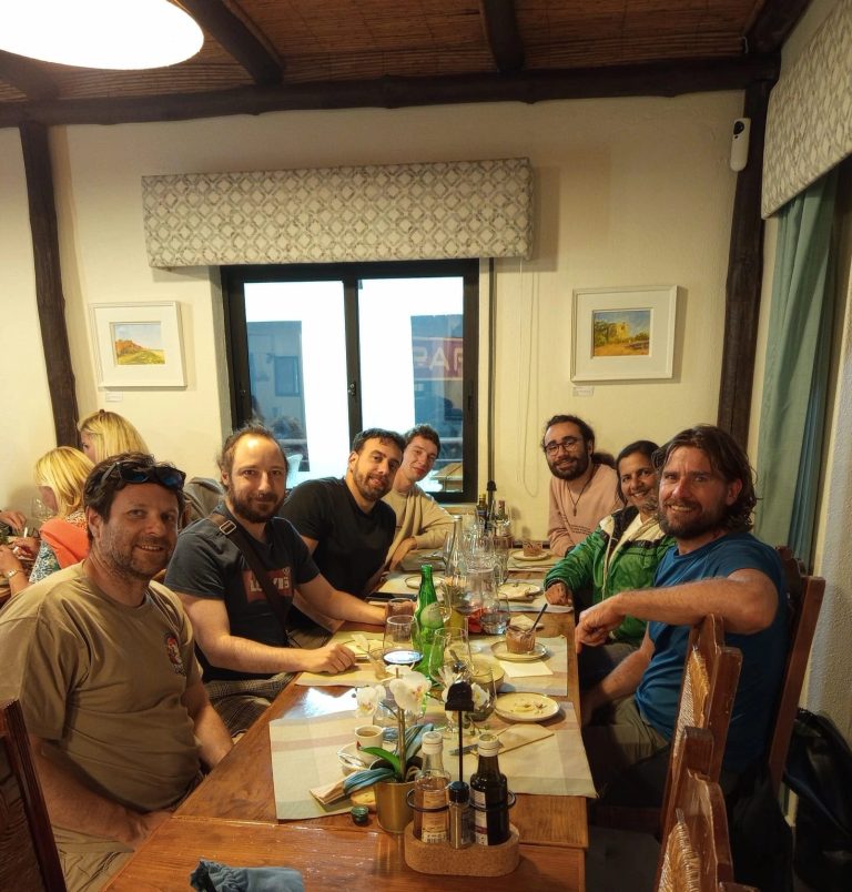 Expedition members sharing a meal around a long table