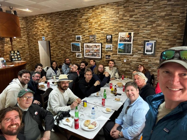 Expedition members at a long table in a restaurant