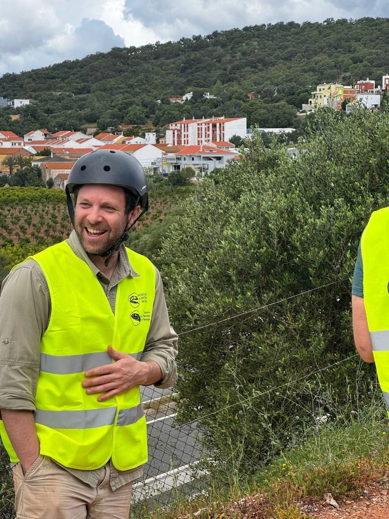 Team member in a helmet and safety vest smiling
