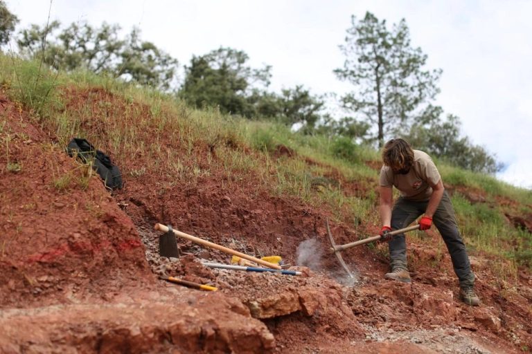 Team member digging into a red slope with a pickaxe