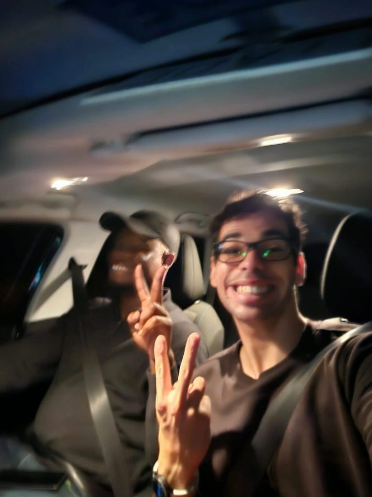 2 team members smiling in the car